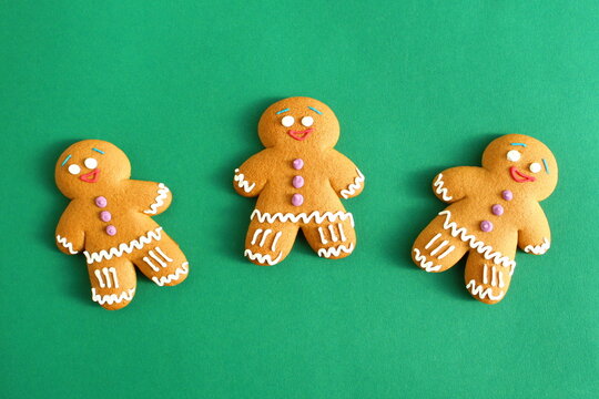 Three gingerbread cookies lie on a green background.