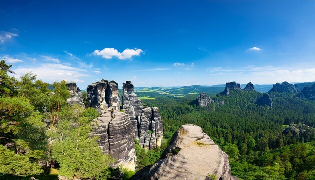 scenic view of the schrammsteine rock formations and falkenstein in saxon switzerland national park under a blue sky summer
