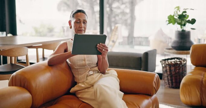 Woman, tablet and relax on couch with smile, online puzzle and down time hobby in living room. Mature person, technology and chill in home with ebook, media subscription and reading with scroll