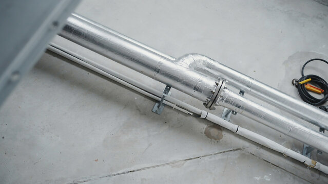 Industrial metal pipes and conduit on concrete surface keywords: pipes, industrial, metal