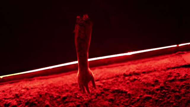  Halloween horror decoration with a severed arm hanging under deep red light creating a brutal haunted house atmosphere with fear darkness and disturbing suspense at night