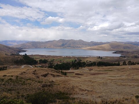 view of lagoon and mountains with cloudy sky in mosoc llacta, cusco, peru