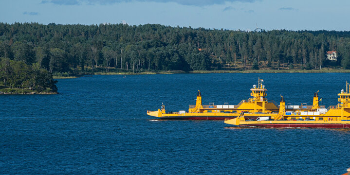 ?ster?ker, Sweden - August 04 2025: Yellow ferries sailing in deep blue waters.