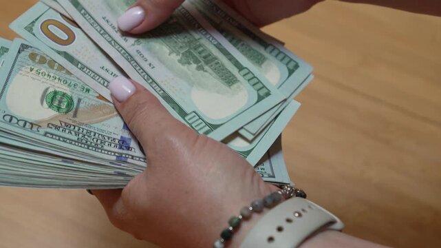 Money, cash, currency, hand holding and counting stack of hundred dollar bills for finance and business banking concepts