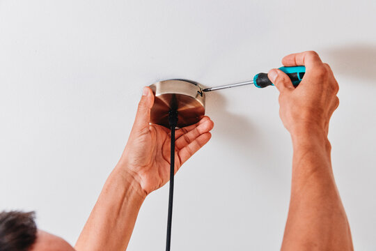 securing a ceiling light canopy with a screwdriver
