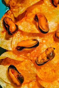 glossy mussels on escabeche-soaked potato chips