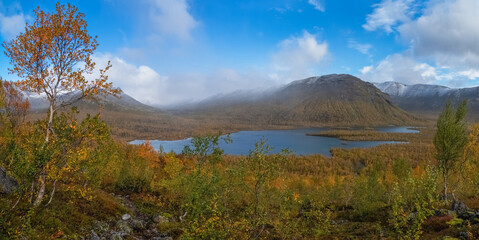 Wide panoramic view of a wild boreal lake and misty mountains in autumn © sablinstanislav