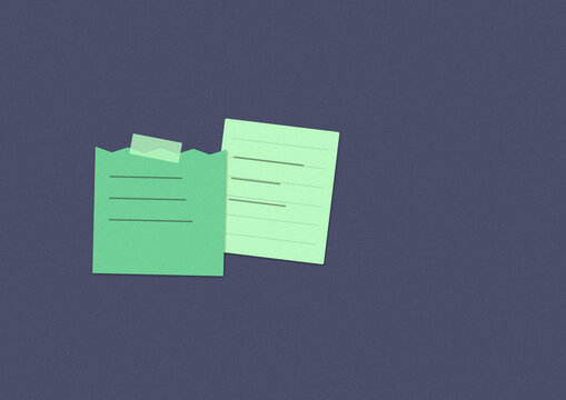 Two torn green sticky notes on dark background