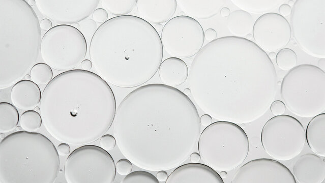 Close-up of various transparent oil droplets on a white surface for scientific or commercial use