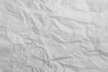 Fototapeta premium Heavily crumpled white paper texture background with detailed wrinkles and folds