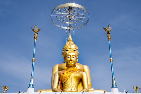 Golden Buddha statues next to ornate lanterns at a temple in Thailand