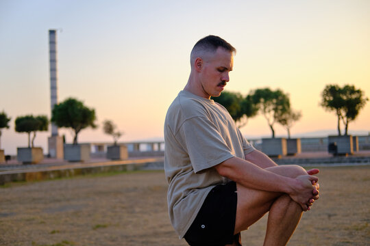 side view of Man stretching outdoors exercising during golden hour in barcelona