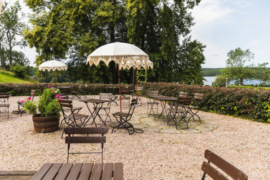 Outdoor cafe patio with fringed parasols overlooking a lake