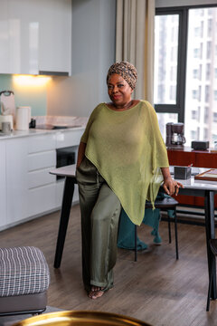 A confident woman posing in her modern home kitchen
