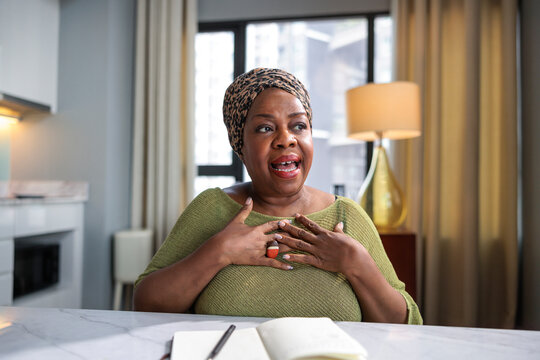 Expressive Black woman gesturing while speaking at a desk