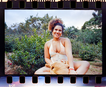 Woman sitting in garden with straw bag