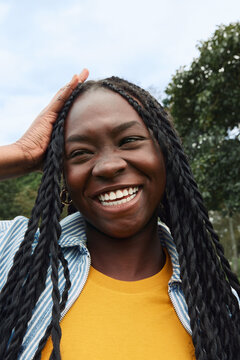 Happy woman with braids smiling outdoors