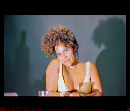 Woman leaning on table with hard shadow on wall