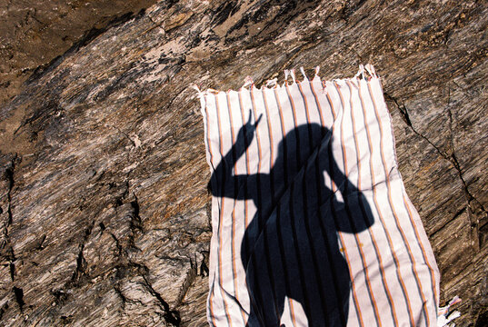 Summer vacation shadow selfie with rock and beach towel