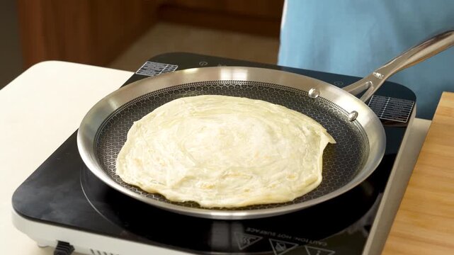 Oil Drizzled on Paratha for Cooking