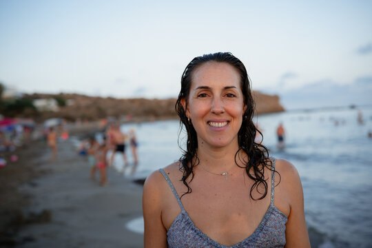 Woman smiling with wet hair on a summer beach