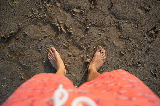 Person standing barefoot on beach sand
