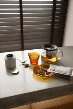 Herbal Chamomile Tea Brewing on Concrete Countertop with Window Blinds