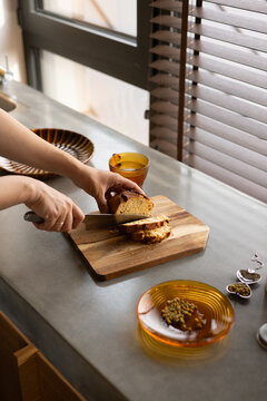 Slicing Fresh Artisanal Bread on a Modern Concrete Kitchen Counter