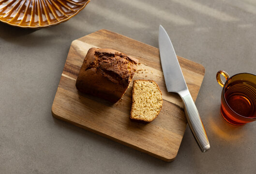 Freshly Sliced Banana Bread on Wooden Cutting Board with Kitchen Knife