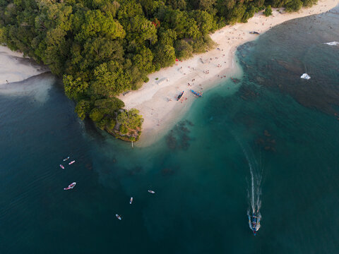 Tropical Cove with Paddleboarders and Speedboat