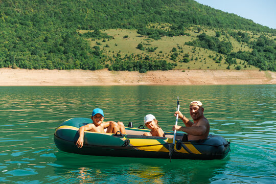 Family Summer Boat Ride On Lake With Father And Children