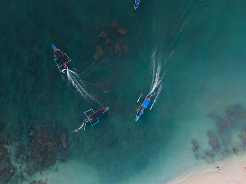 Outrigger Boats Crossing Turquoise Water from Above