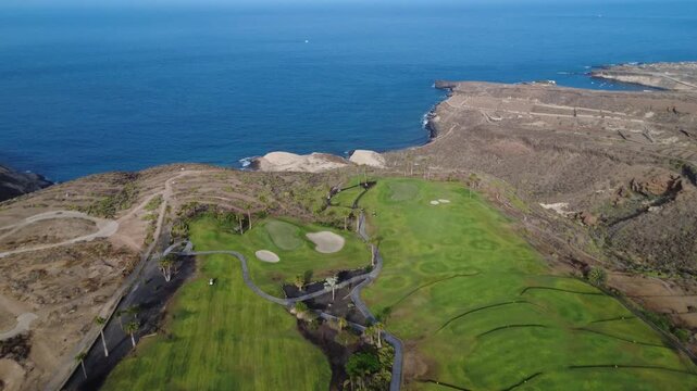 Dron vuela sobre la &uacute;ltima calle de golf y revela acantilados de roca blanca y la costa atl&aacute;ntica azul profundo, Adeje, Tenerife