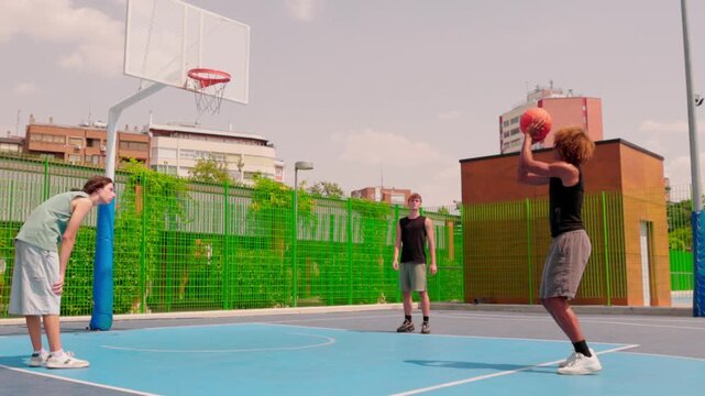 Multicultural friends playing basketball on an outdoor court