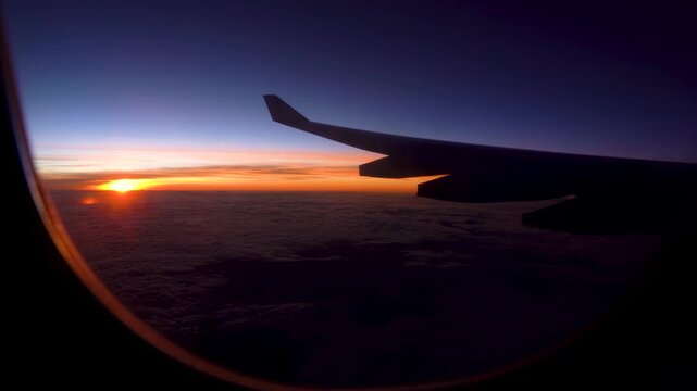 A Breathtaking Sunrise Captured from a Window Seat, Showcasing the Wing of an Airplane Against a Vibrant Sky Filled with Clouds and Warm Hues
