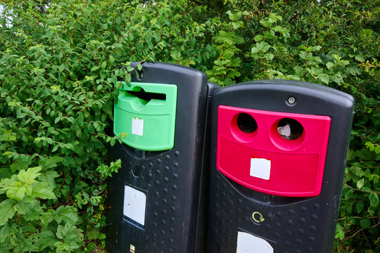 Close-up of two plastic recycling bins in a public park. Waste management and sustainability. Responsibility in material separation.