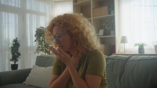 Portrait of ill young woman at home having cough and sore throat. First symptoms of cold and flu virus, pneumonia, bronchitis and respiratory tract infection. Seasonal virus