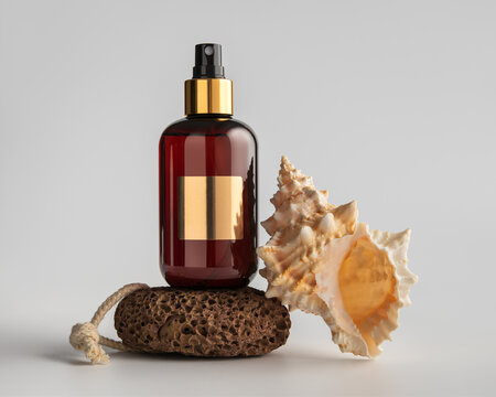 Mockup featuring an amber glass spray bottle mockup with pumice and seashell