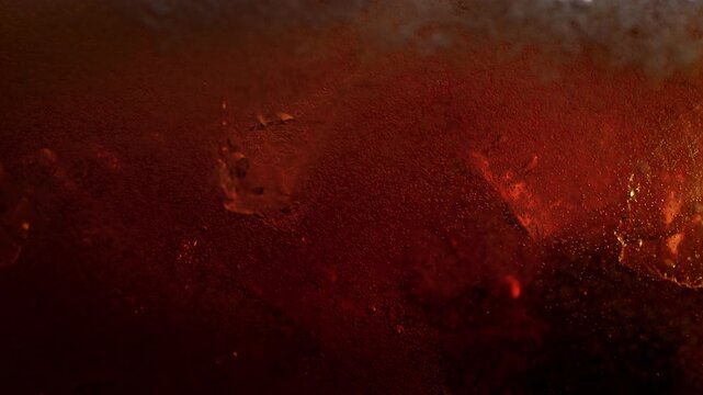 Super Slow Motion Shot of Ice Falling into Fresh Cola Lemonade at 1000fps.