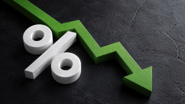 White percentage symbol with green declining arrow on dark textured background interest rate cut concept