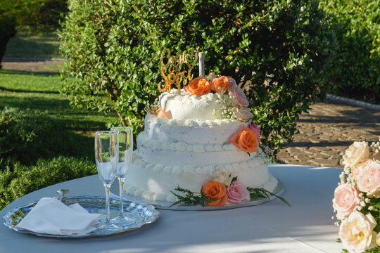 Torta di matrimonio elegante all'aperto con calici da spumante e allestimento floreale