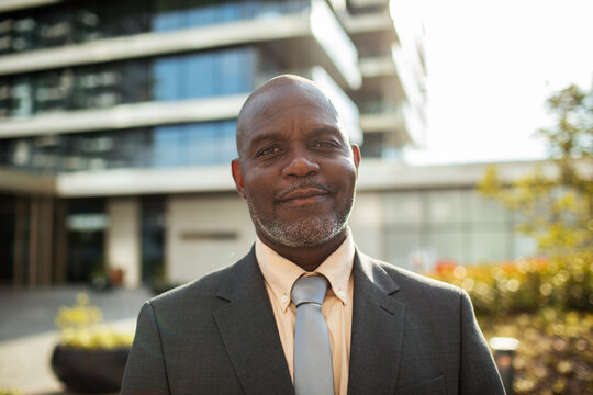 Confident businessman smiling outdoors by office building