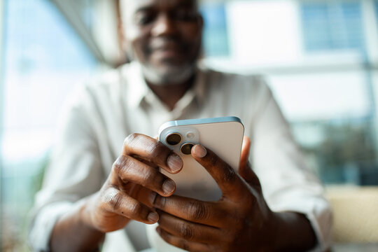 Smiling man using smartphone indoors