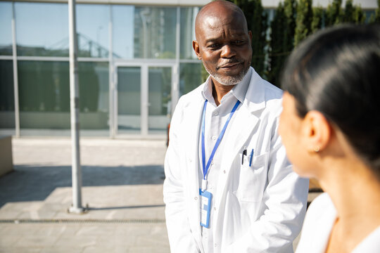 Doctor speaking with colleague outside hospital