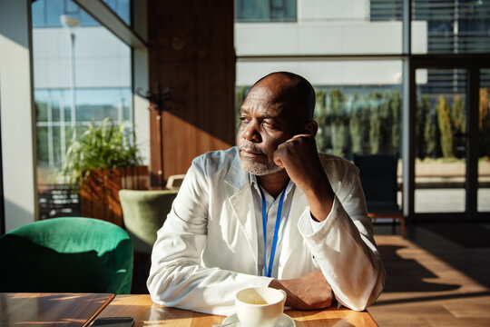 Doctor on coffee break looking out cafe window