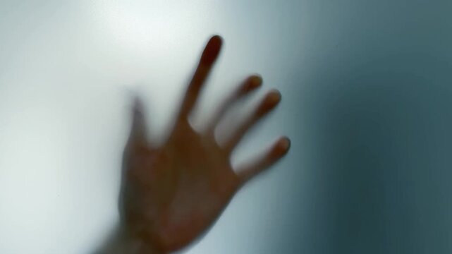 Hand Reaching Toward Frosted Glass and Sliding Away
