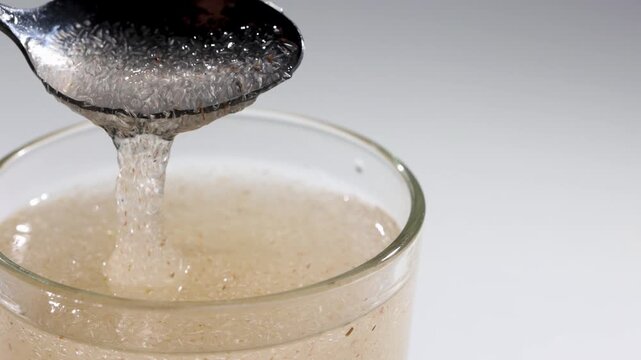 Textured psyllium husk gel forming in water inside a glass in studio