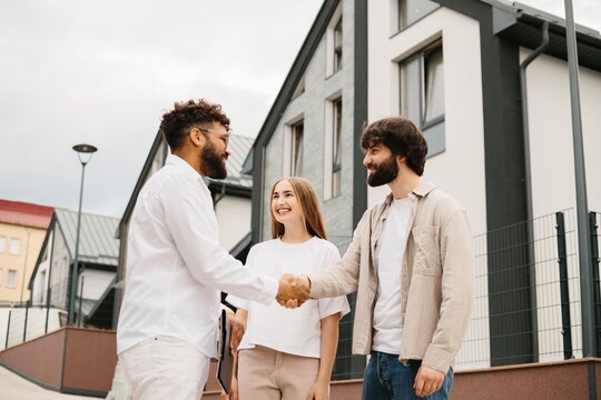 Real estate agent shaking hands with new homeowners