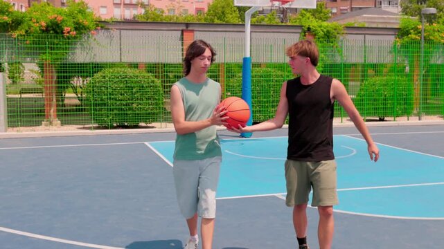 Two young friends playing basketball on an outdoor court