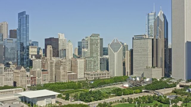 Chicago Illinois Aerial v60 establishing pull out shot away from contemporary high rise buildings reveals beautiful millennium park surrounded by futuristic downtown cityscape - August 2020